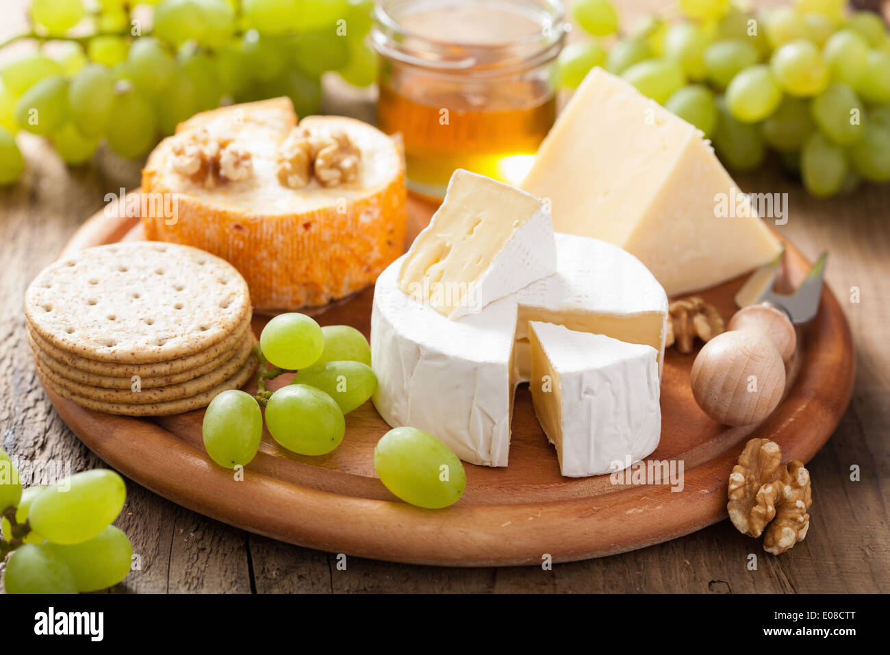 Assiette de fromage avec camembert, cheddar, les raisins et le miel Banque D'Images