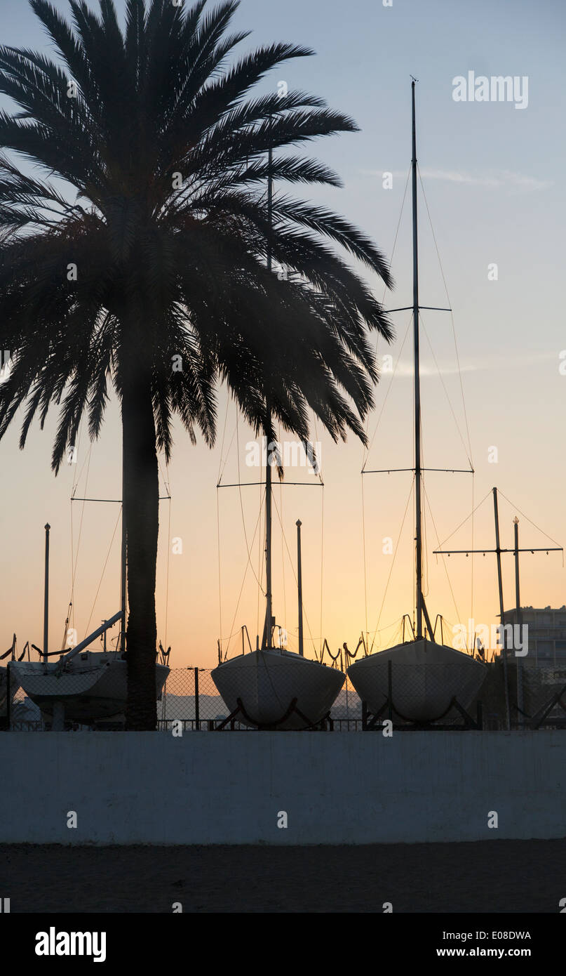 Bateaux à voile en cale sèche à Puerto Deportivo de Marbella au coucher du soleil. (Málaga, Andalousie, Espagne). Banque D'Images