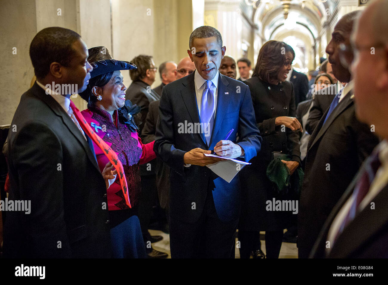 Le président américain Barack Obama signe une copie de son discours pour rempl. Frederica Wilson, dans un couloir à l'extérieur de la Chambre des communes comme lui et la Première Dame Michelle Obama départ après l'état de l'Union à la capitale américaine le 28 janvier 2014 à Washington, DC. Banque D'Images