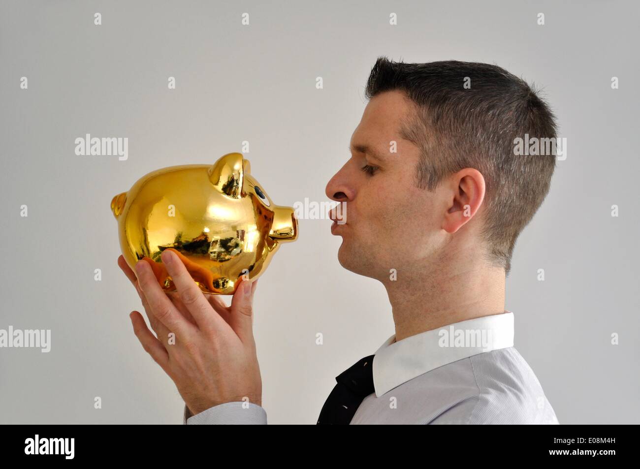 Illustration - un homme embrasse un golden Piggy Bank en Allemagne, le 27 février 2011. Photo : Berliner Verlag/Steinach - PAS DE SERVICE DE FIL Banque D'Images