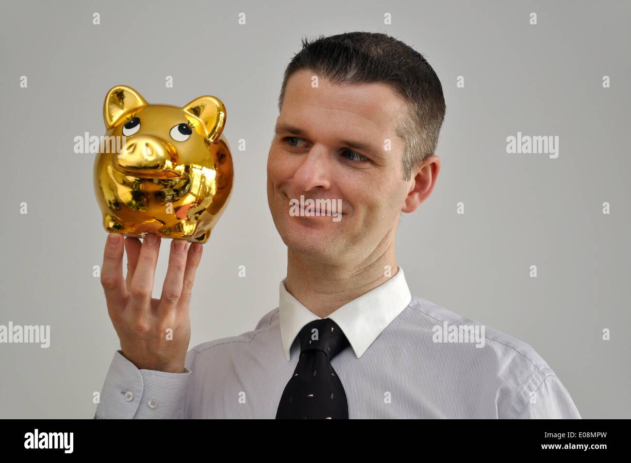 Illustration - Un homme est titulaire d'un golden Piggy Bank en Allemagne, le 27 février 2011. Photo : Berliner Verlag/Steinach - PAS DE SERVICE DE FIL Banque D'Images