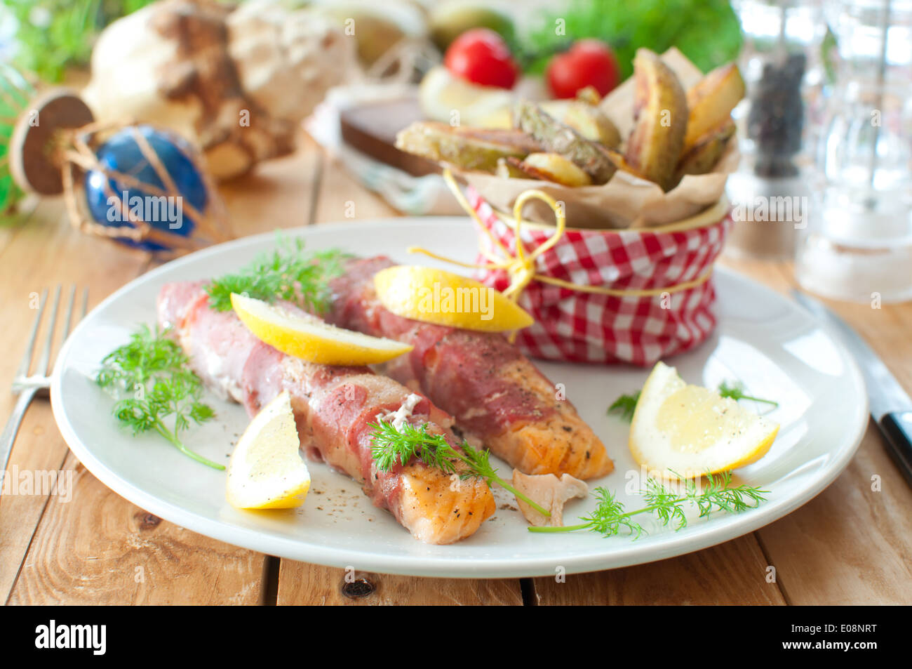 Filets de saumon enveloppé de bacon avec les quartiers de pommes de terre Banque D'Images