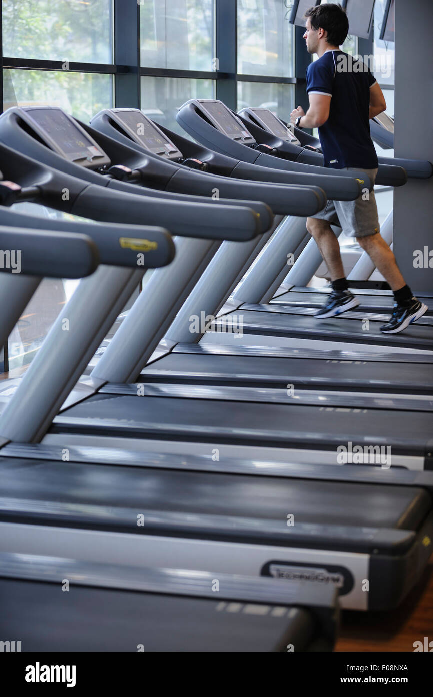 Jeune homme qui court sur un tapis roulant Banque D'Images