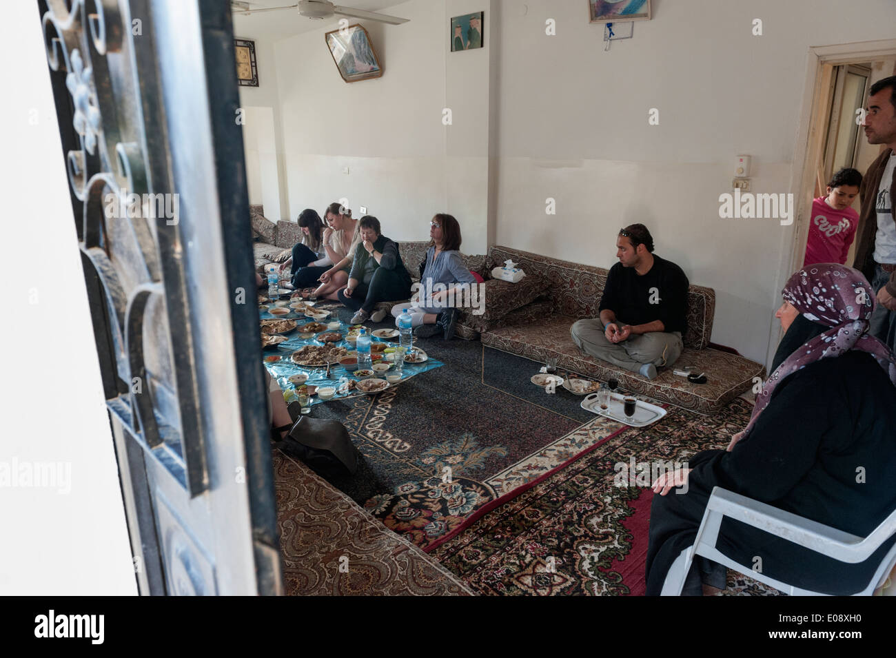 Un groupe de touristes ayant un déjeuner traditionnel avec une famille locale dans le village près de orjan al ayoun trail. La Jordanie Banque D'Images