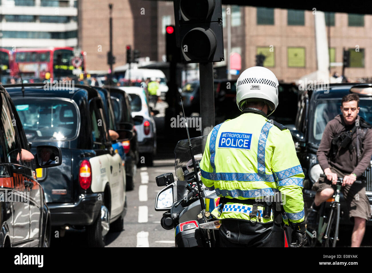 Londres, Royaume-Uni. 6 mai 2014, un agent de moto métropolitaine, impuissant, regarde le contre-taxis dans les rues de Southwark pour protester contre le refus de placer un taxi noir de taxis devant l'entrée du fragment. Photographe : Gordon 1928/Alamy Live News Banque D'Images