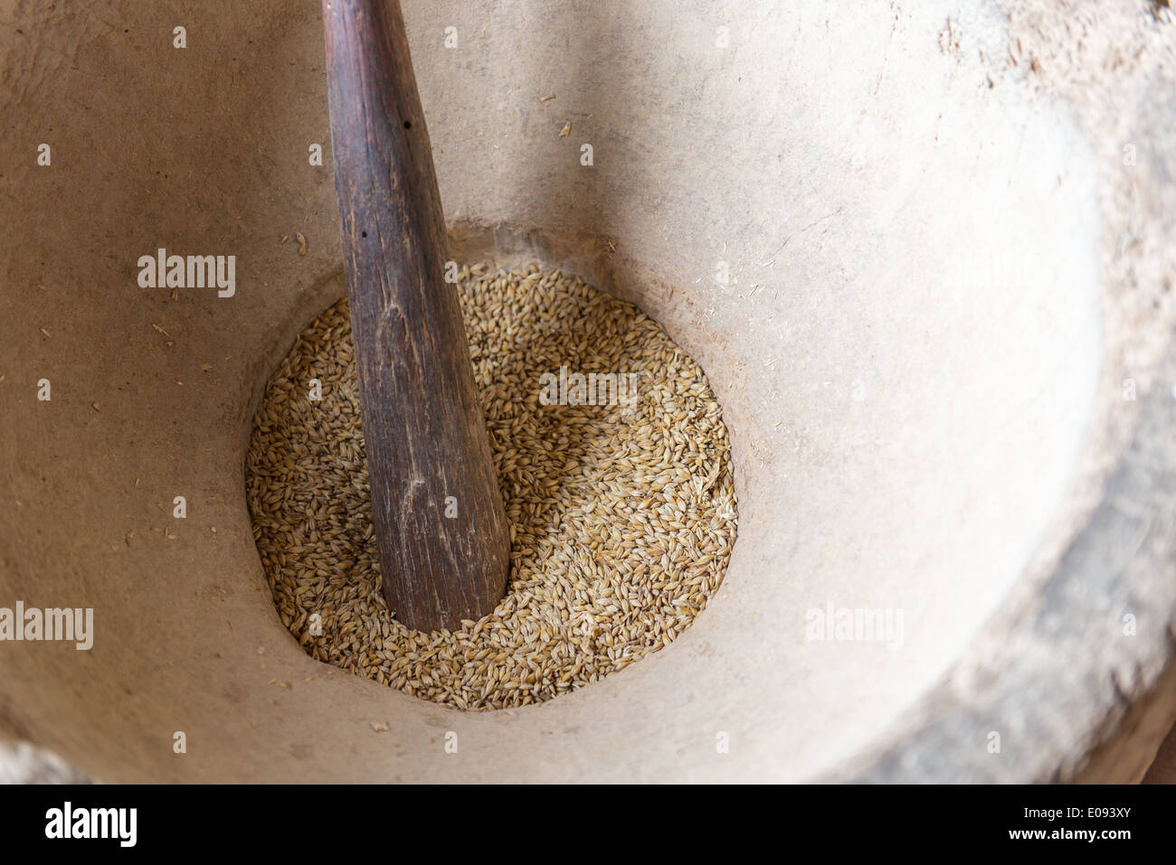 Grand mortier traditionnel en pierre avec pilon en bois et de maïs frais Banque D'Images