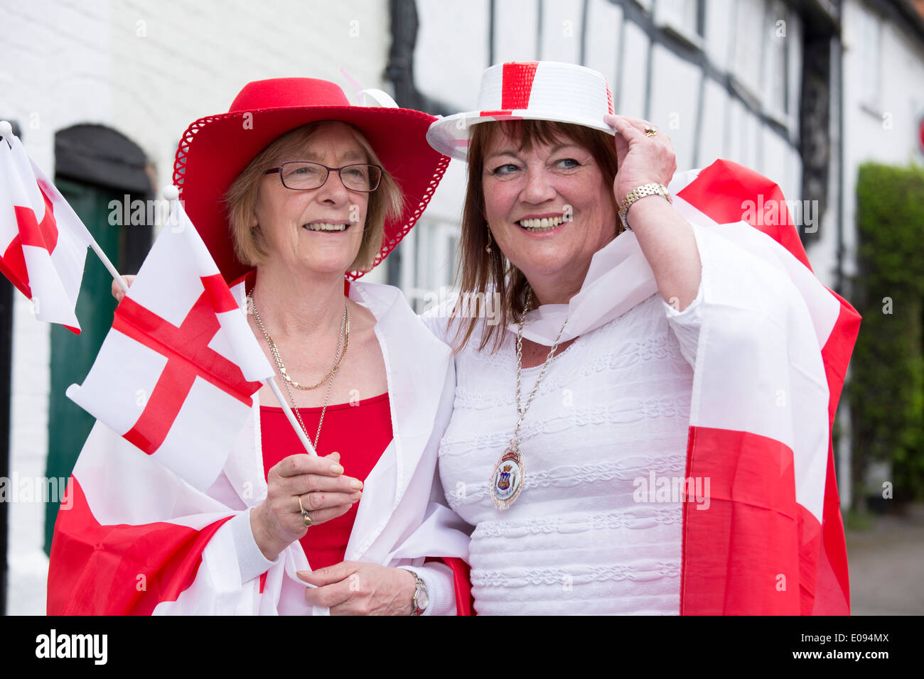 St George's Day Parade, Stratford-upon-Avon, Warwickshire. Sur la photo deux dames habillé en rouge et blanc tenant des drapeaux anglais. Banque D'Images
