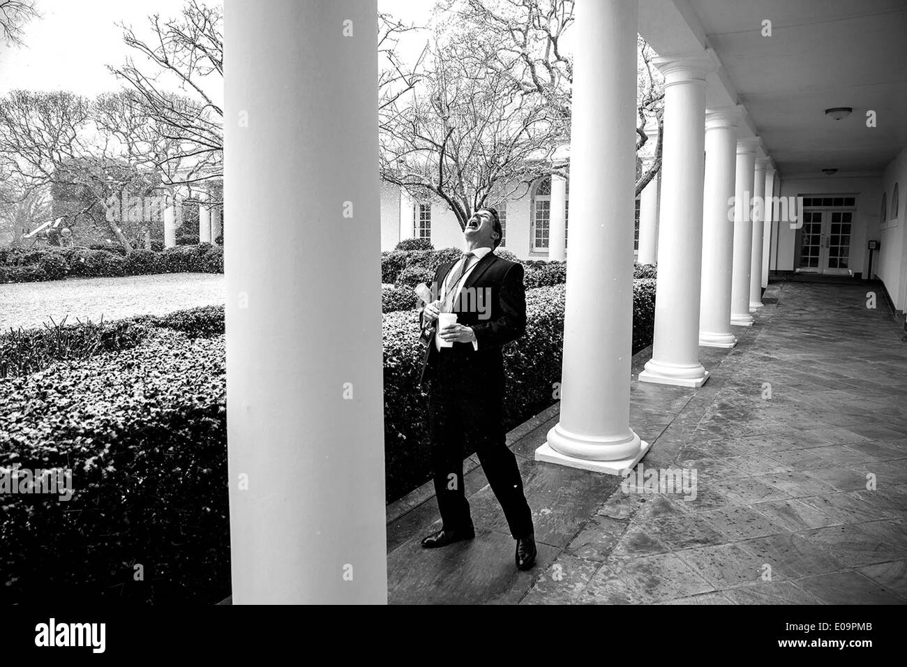 Secrétaire sociale Jeremy Bernard captures flocons dans sa bouche pendant qu'il marche le long de la Colonnade de la Maison Blanche le 25 février 2014 à Washington, DC. Banque D'Images