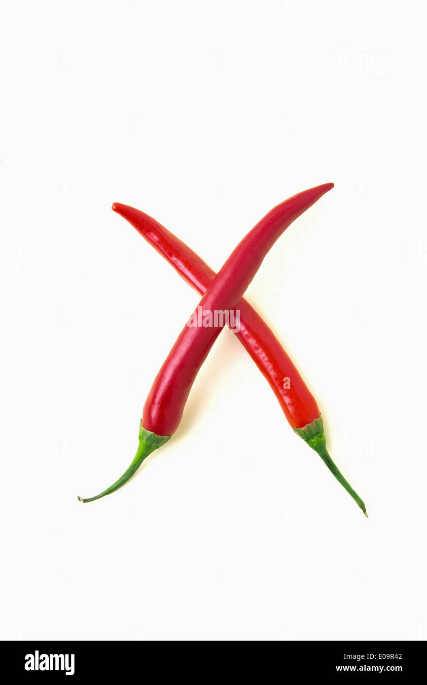Poivrons rouges en forme de lettre X in front of white background Banque D'Images