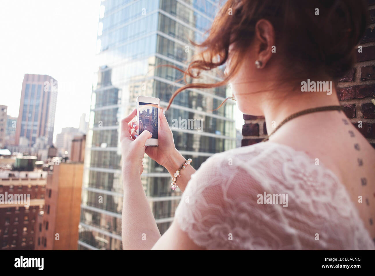Young woman using smartphone pour photographier Manhattan, New York City Banque D'Images