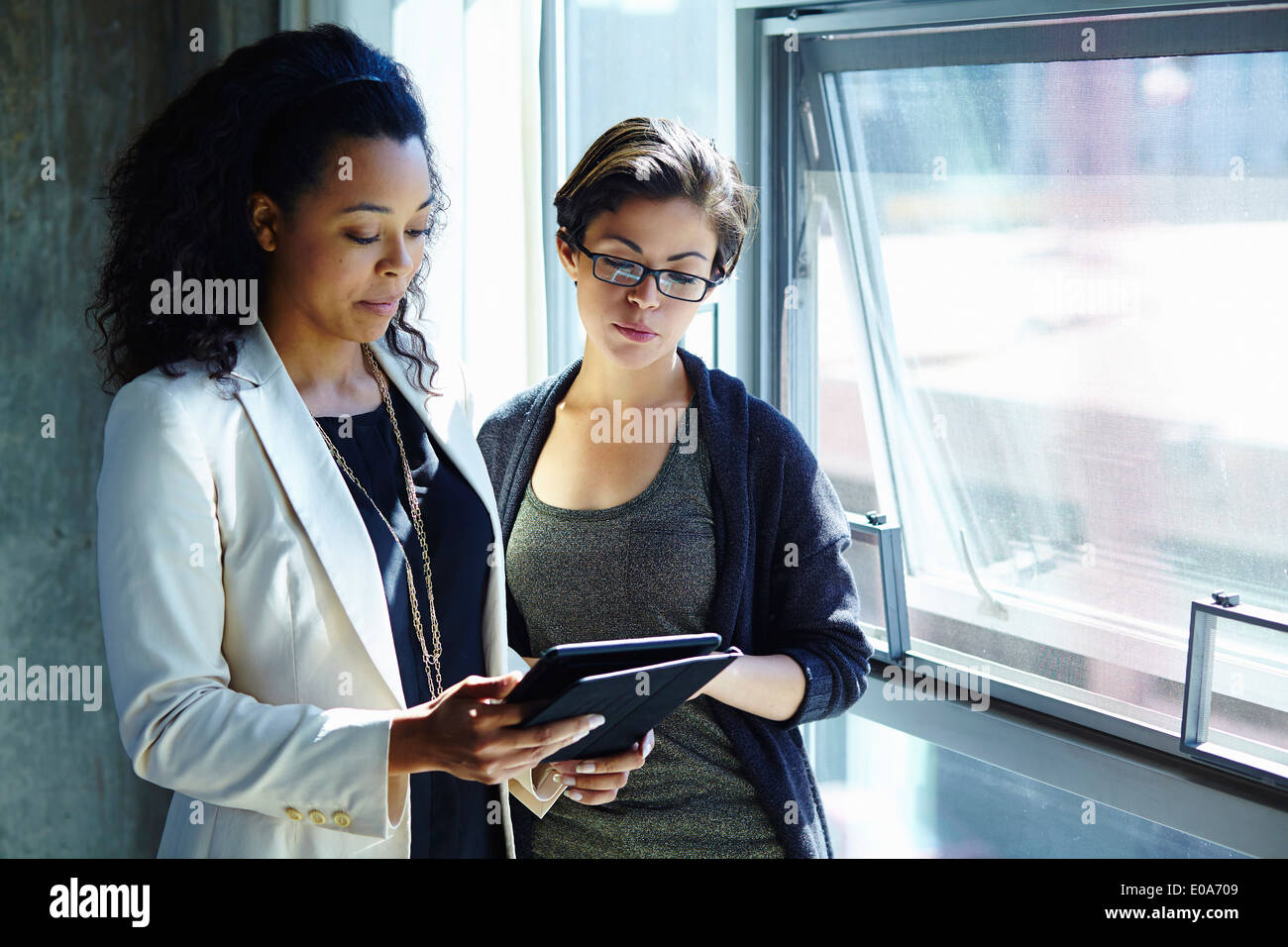 Two businesswomen looking at digital tablet in office Banque D'Images