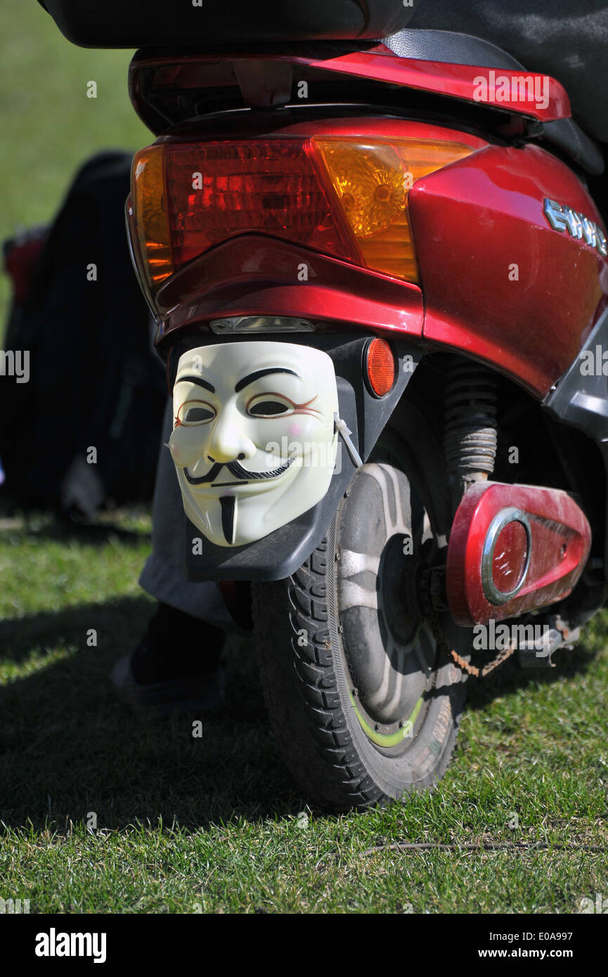 Un masque anonyme sur le garde-boue arrière d'un scooter. Banque D'Images