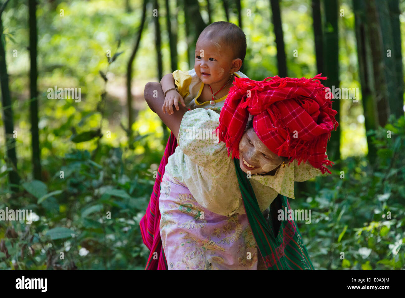 Pa-O woman wrapping bébé sur le dos, au Lac Inle, l'État de Shan, Myanmar Banque D'Images