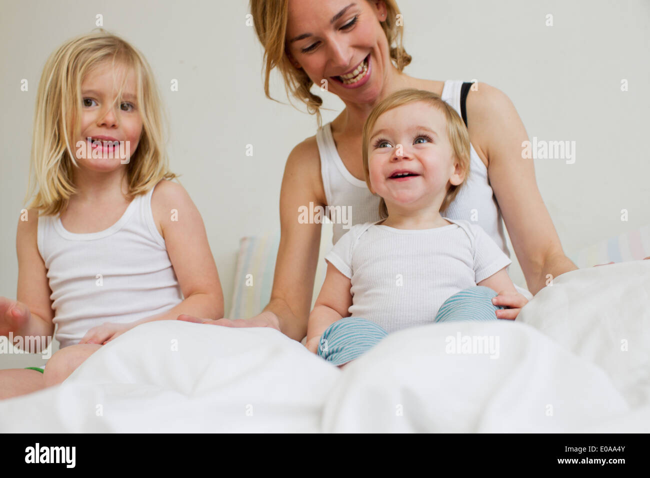 Portrait of mid adult woman in bed avec deux filles Banque D'Images