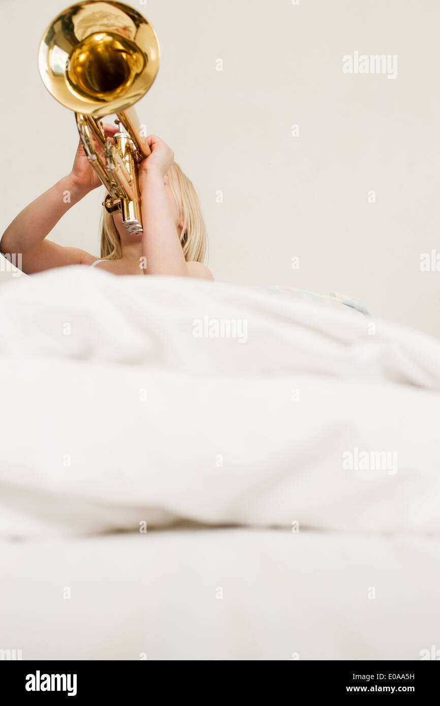 Girl playing Trumpet in bed Banque D'Images