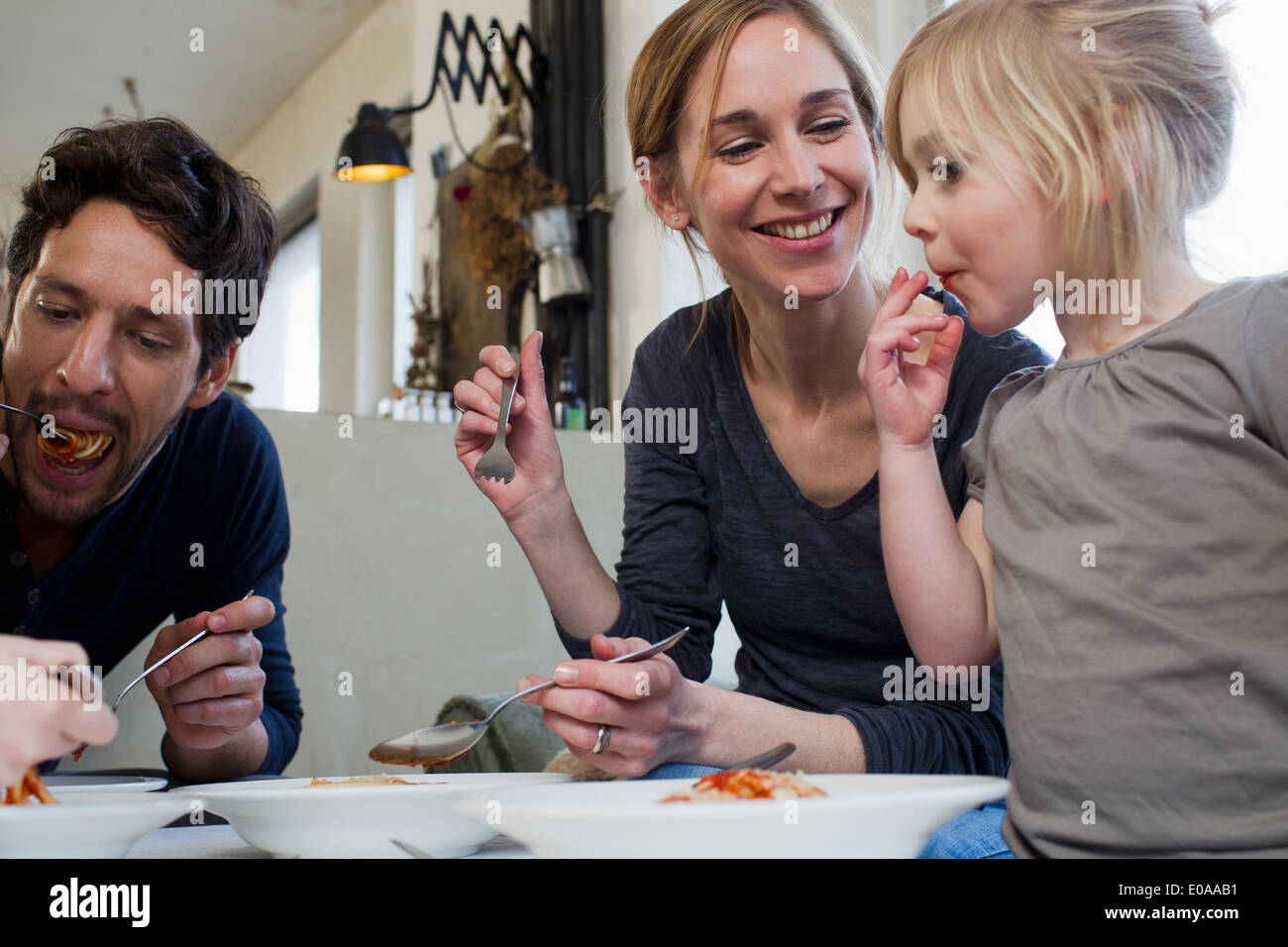 Mid adult parents et deux filles de manger un repas spaghetti Banque D'Images