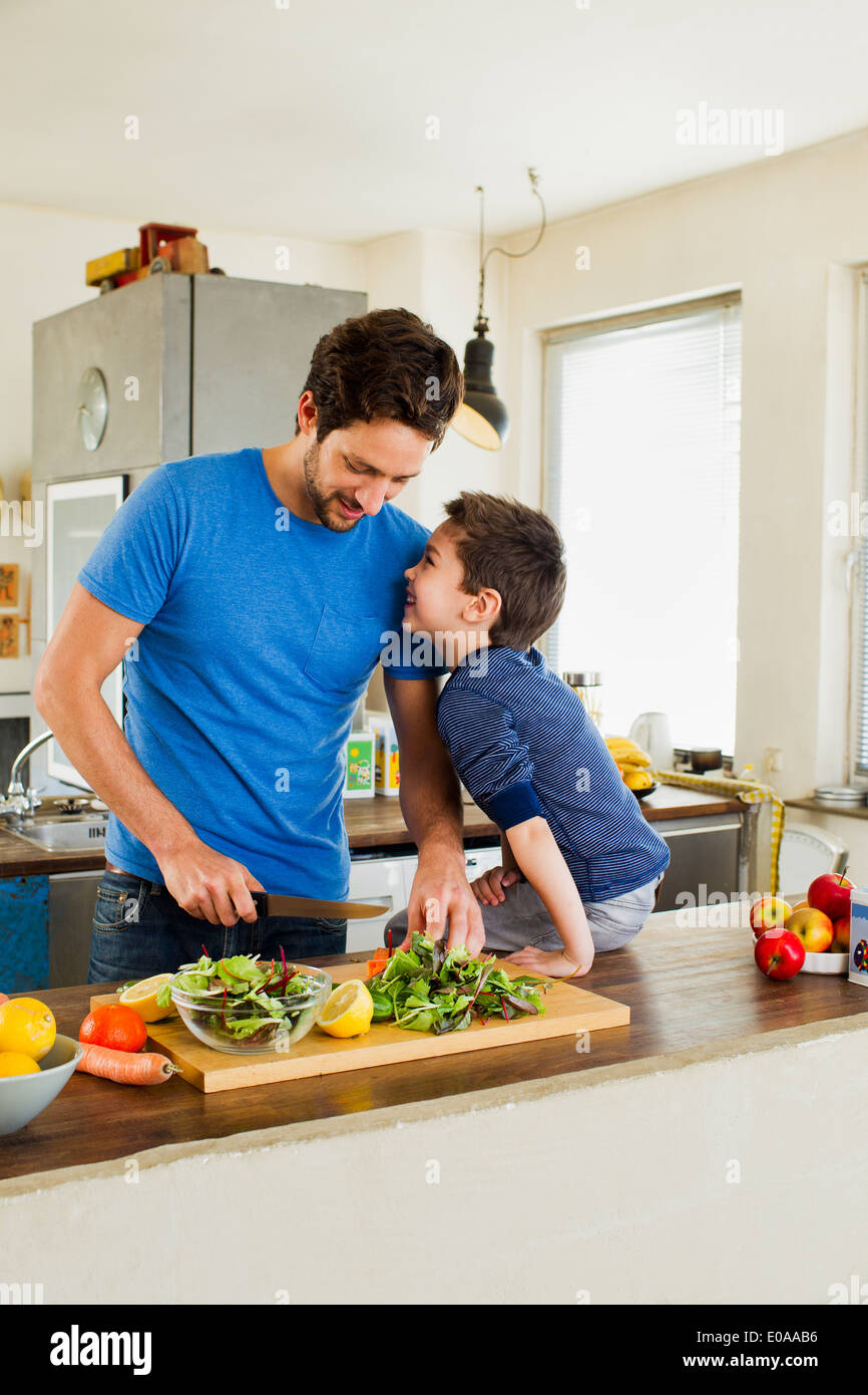 Le père et le jeune fils de la préparation de légumes dans la cuisine Banque D'Images