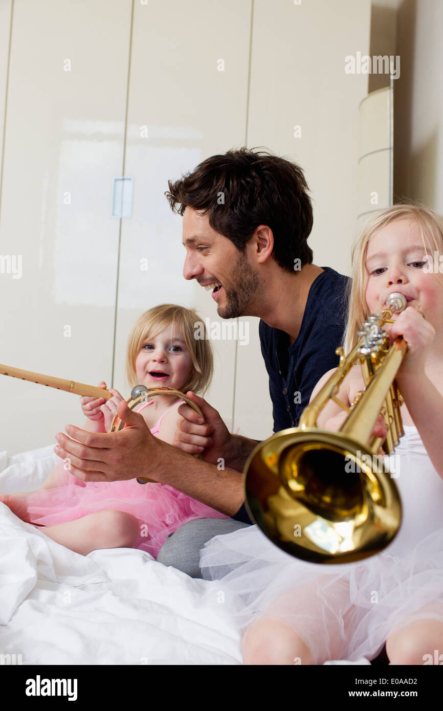 Et père de deux jeunes filles jouant de la musique Banque D'Images