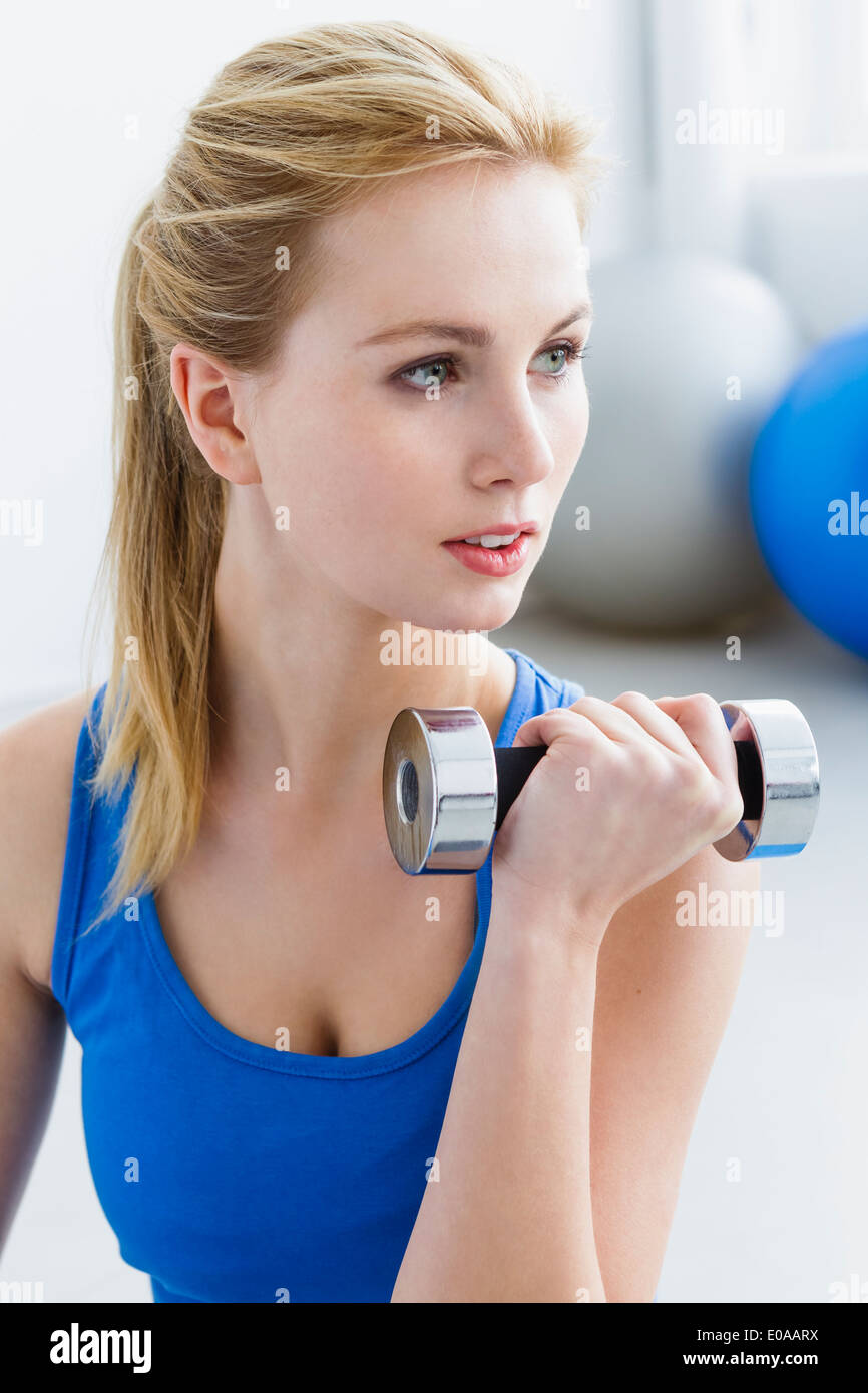 Young woman lifting weights Banque D'Images