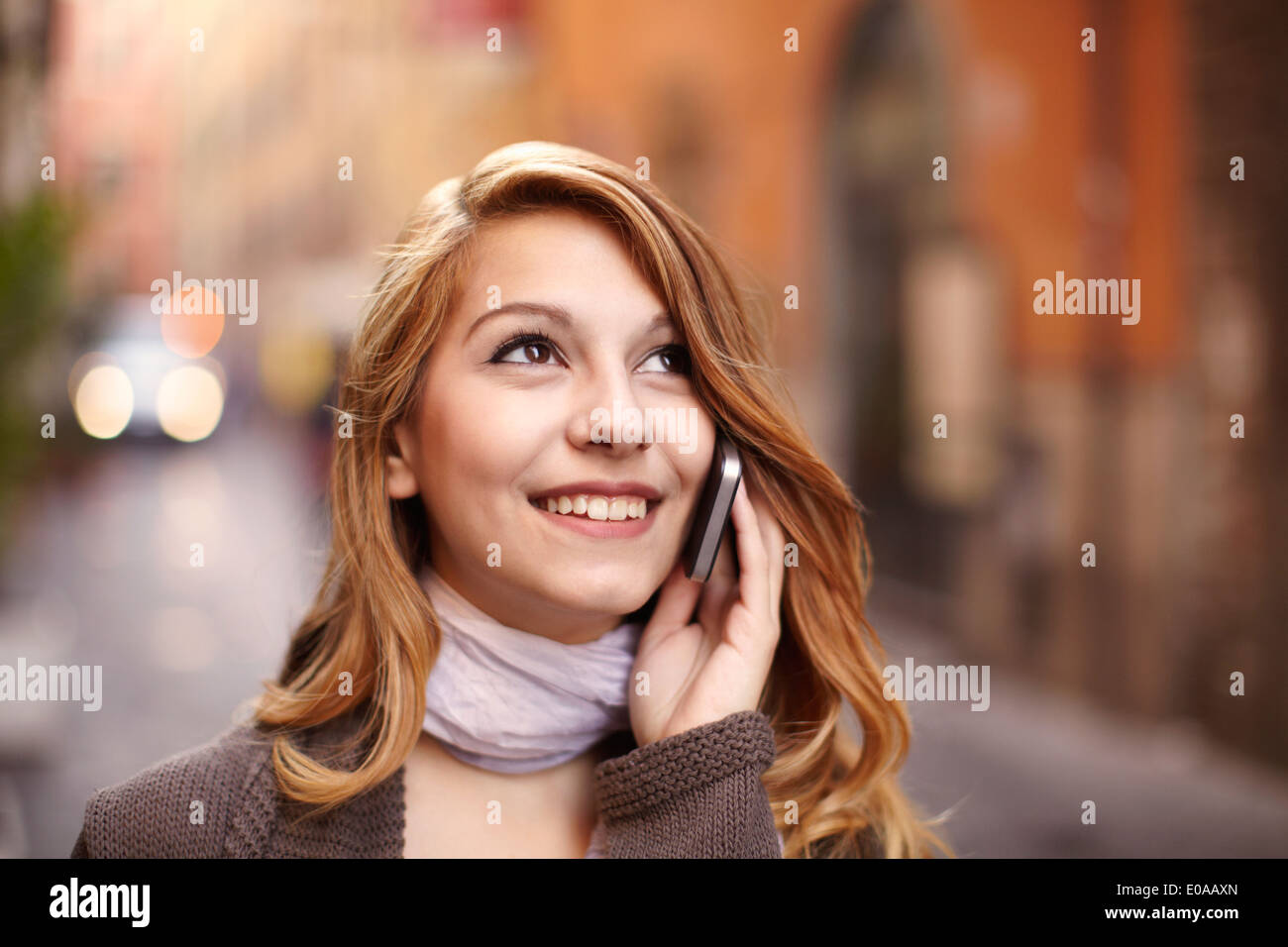 Young woman chatting on smartphone sur la rue de Rome, Italie Banque D'Images