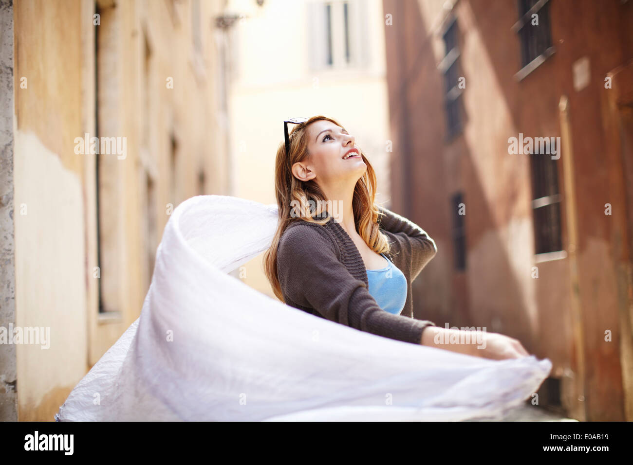Jeune femme tourbillonner son écharpe sur rue, Rome, Italie Banque D'Images