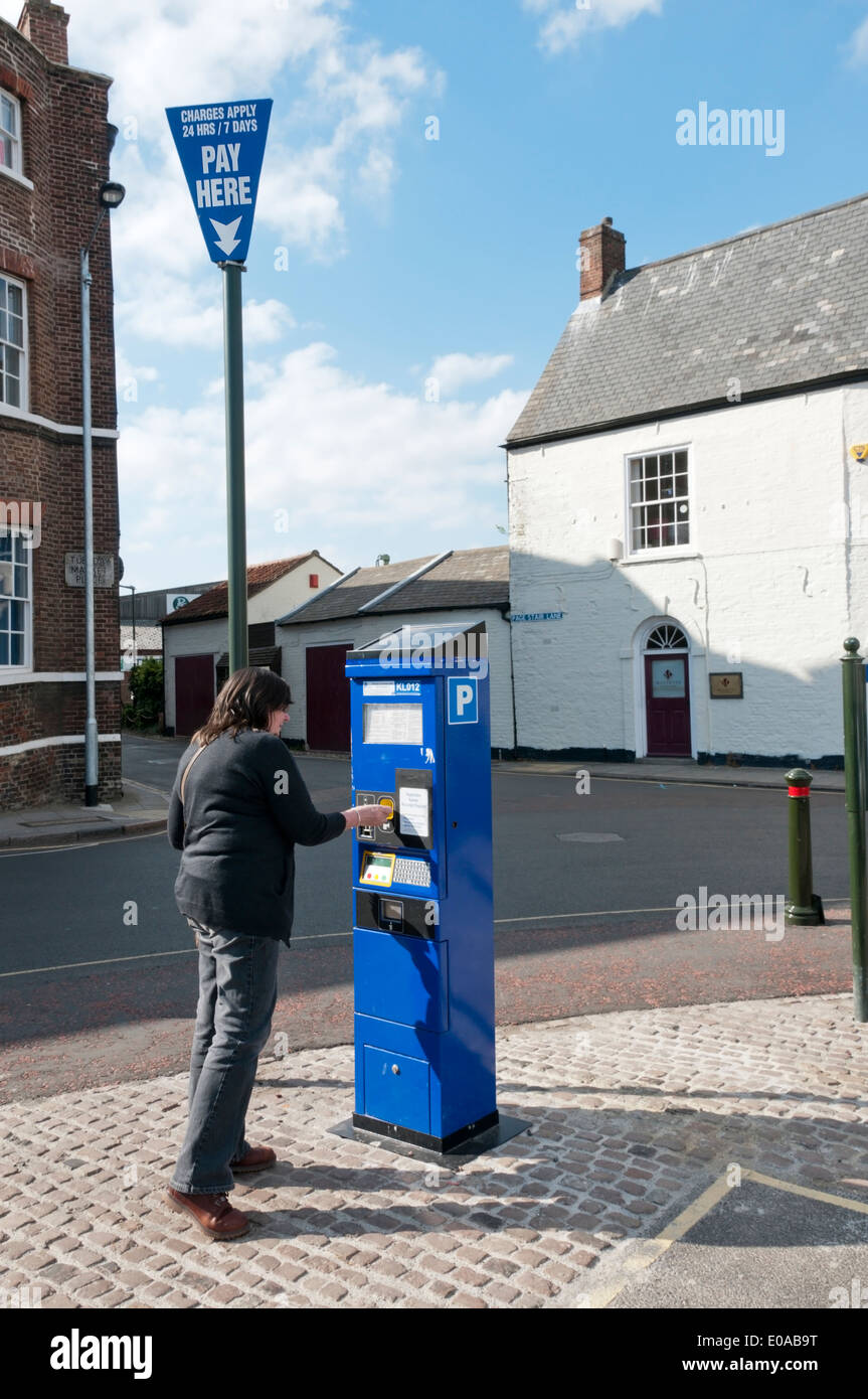 Femme de l'achat d'un ticket de parking à partir d'une machine sur le marché mardi, King's Lynn, Norfolk. Banque D'Images