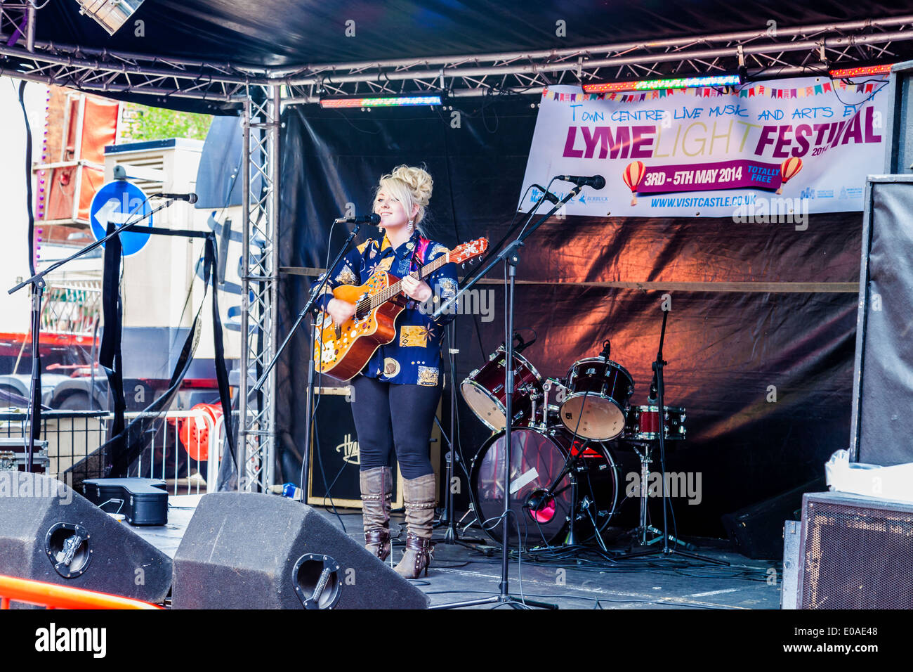 Une adolescente singer, Hollie peut Beeston,chante et joue de la guitare, sur scène, Newcastle Under Lyme,Staffordshire England UK. Banque D'Images