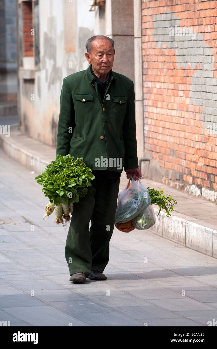 Un homme âgé portant retour à l'accueil de l'épicerie, jianshui, Yunnan, Chine Banque D'Images