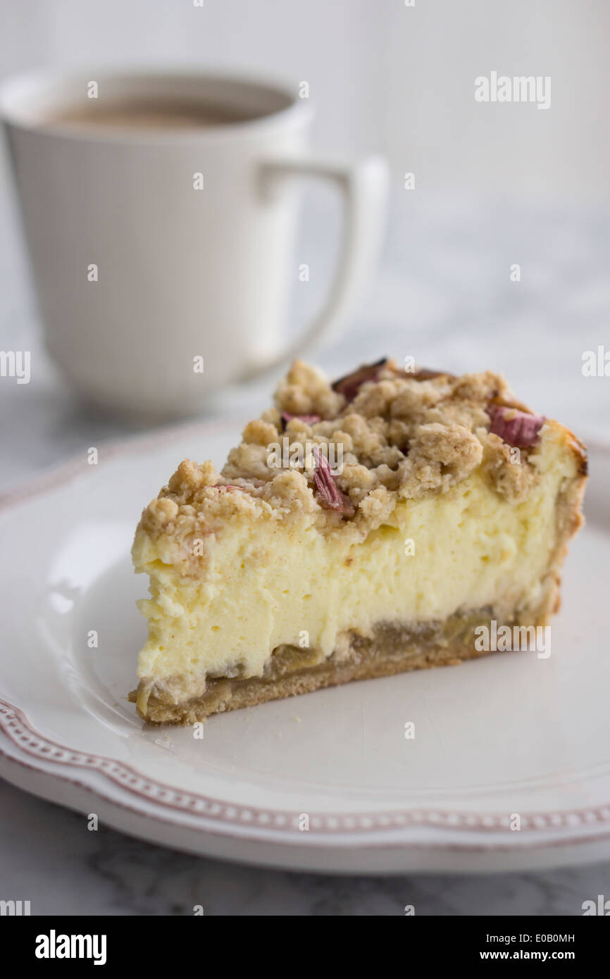 Morceau de gâteau sur une assiette de fromage de rhubarbe avec tasse de café Banque D'Images