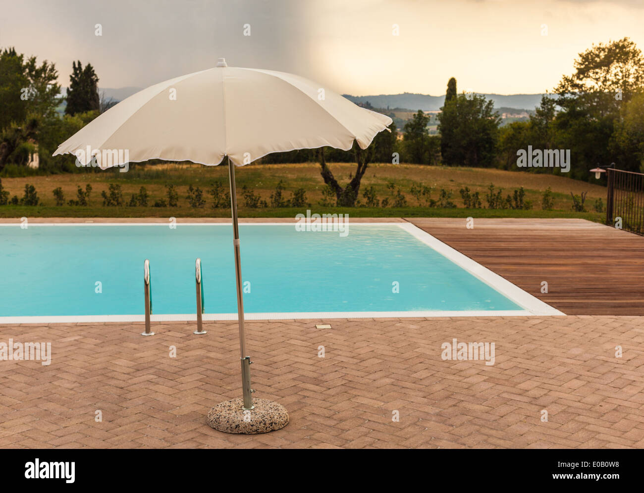 Un parasol près du bord d'une piscine et d'une tempête dans l'arrière-plan  Photo Stock - Alamy