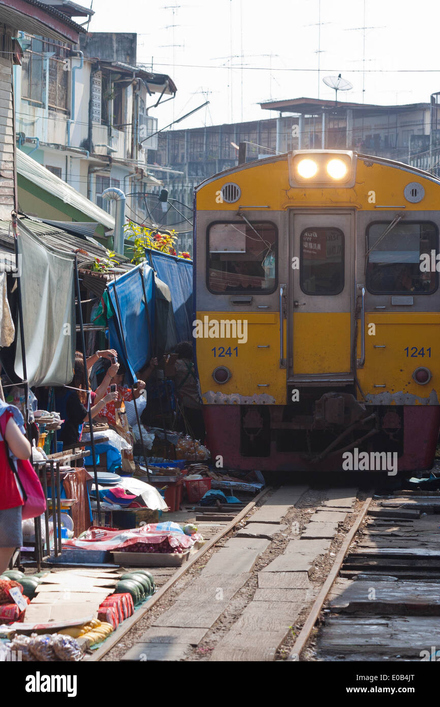 Train venant à travers les voies de chemin de fer Maeklong market, Bangkok, Thaïlande Banque D'Images