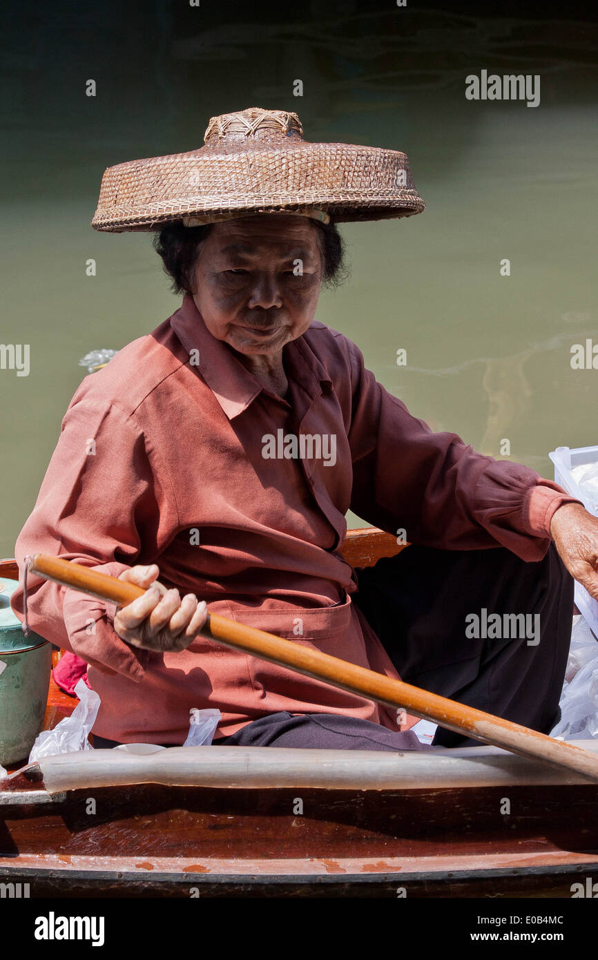 Une femme sur son bateau au marché flottant de Damnoen Saduak, Bangkok, Thaïlande Banque D'Images