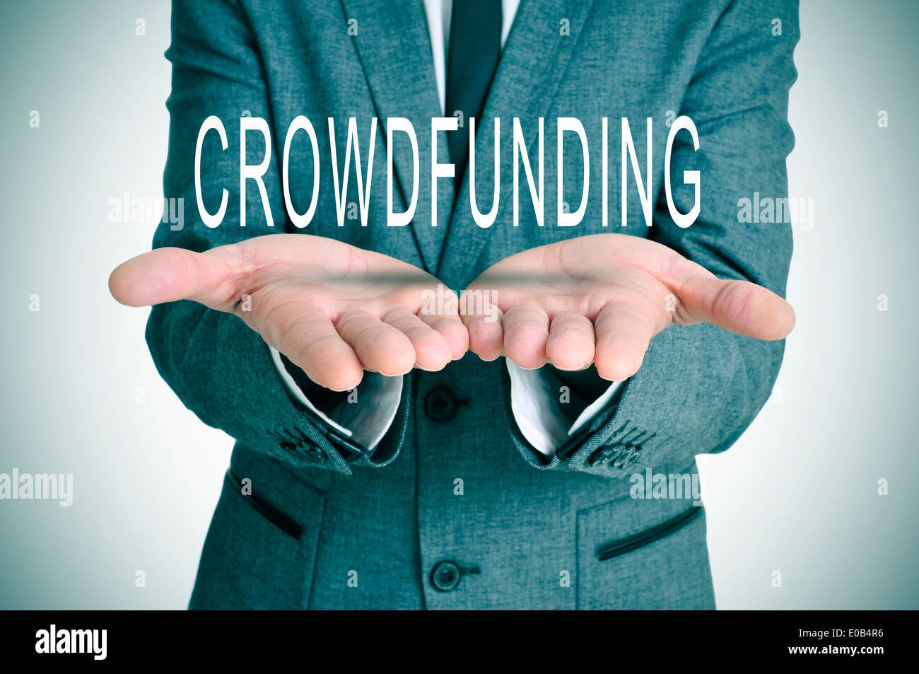 Homme portant un costume holding le mot crowdfunding dans ses mains Banque D'Images