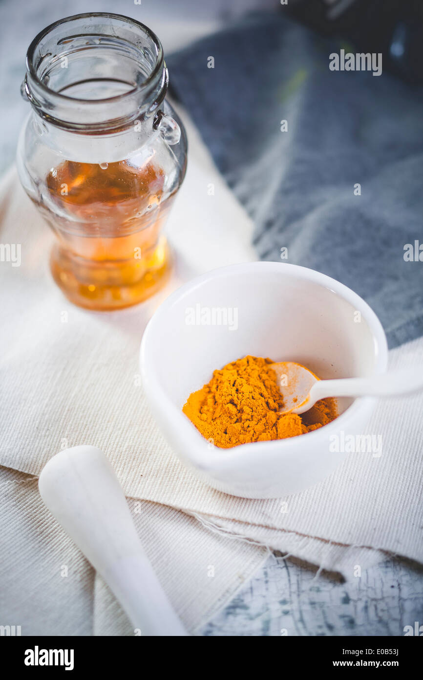 Le curcuma dans le mortier et glas de miel pour la préparation du thé de curcuma Banque D'Images