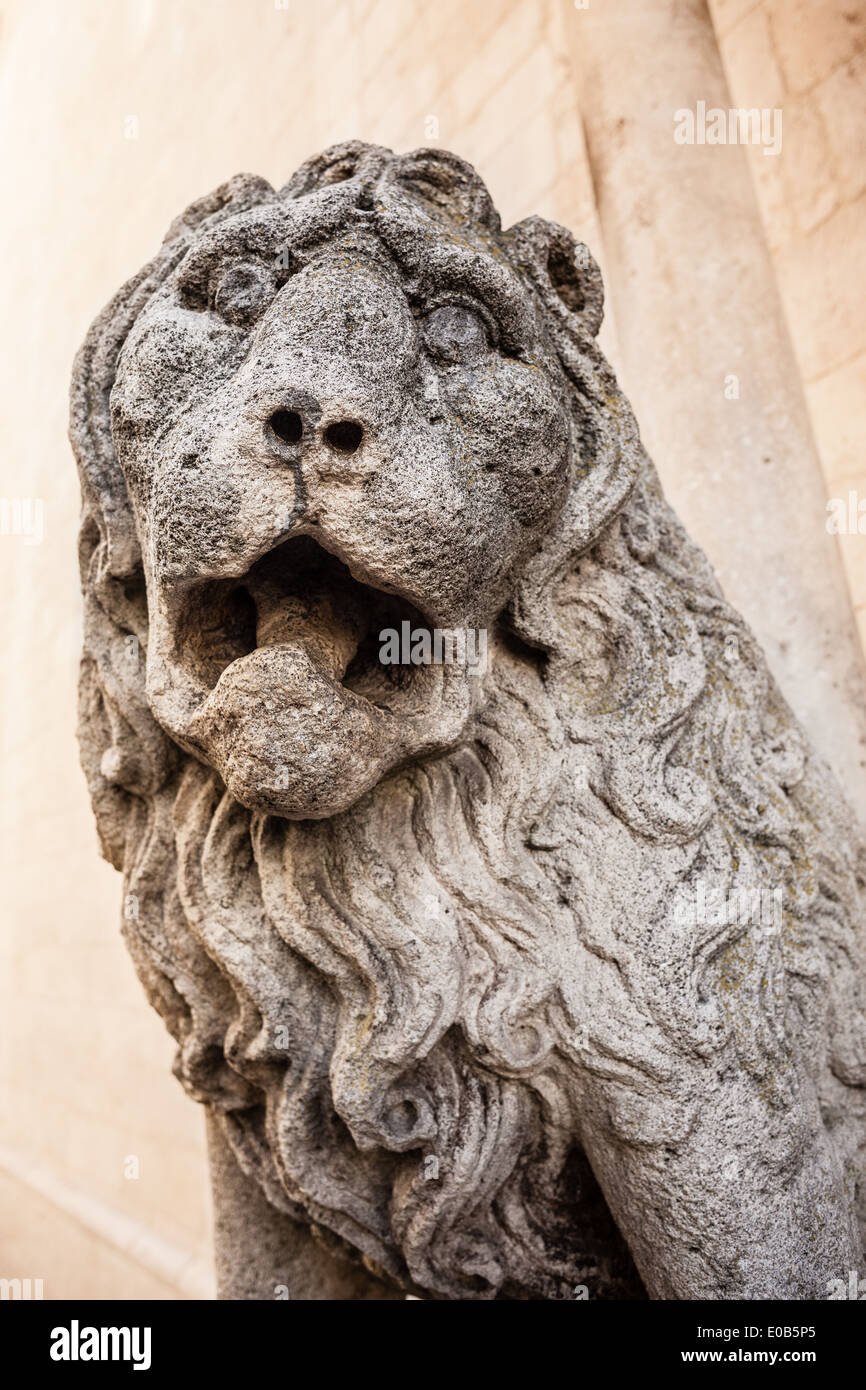La sculpture d'un lion féroce sur un mur de pierre rugissant Banque D'Images