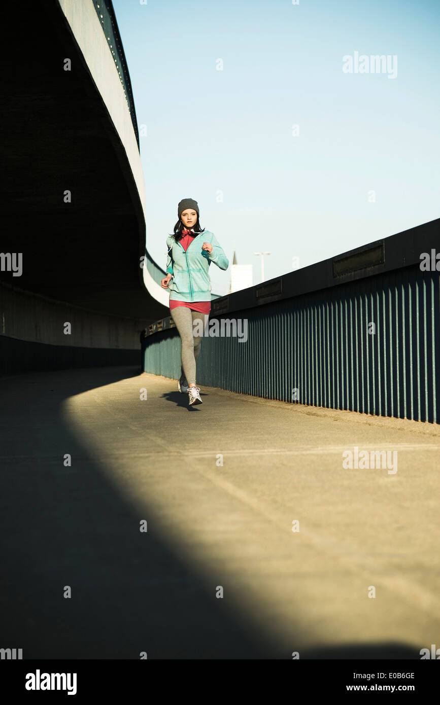 Young female jogger sur la déplacer sur un pont Banque D'Images