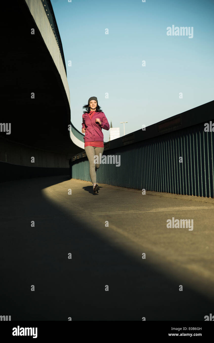 Young female jogger sur la déplacer sur un pont Banque D'Images