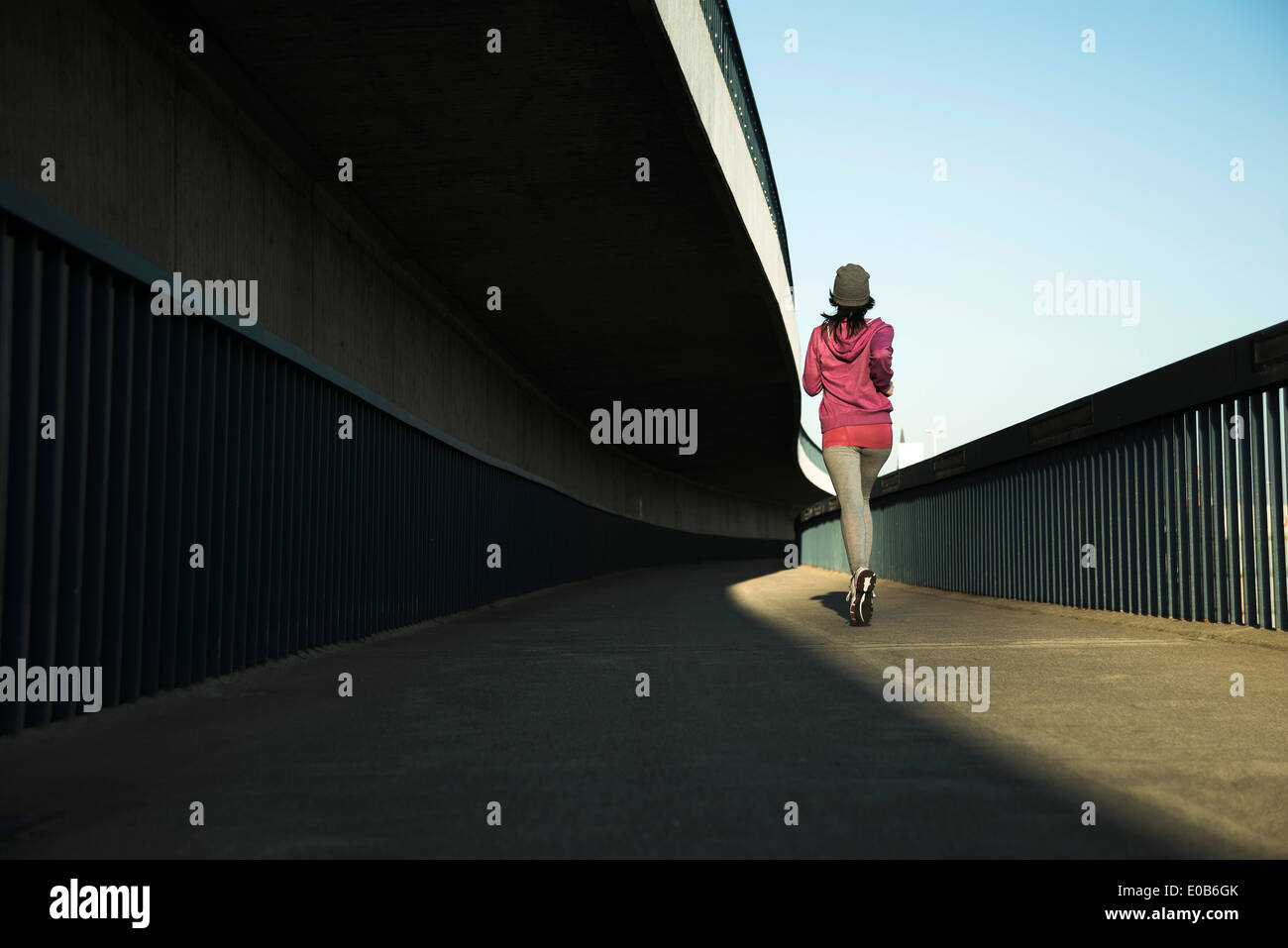 Young female jogger sur la déplacer sur un pont Banque D'Images