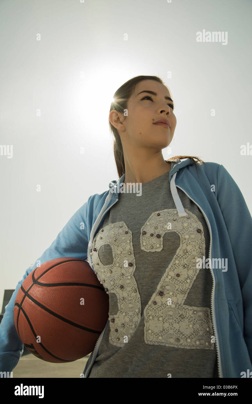 Young woman holding basket-ball extérieur Banque D'Images