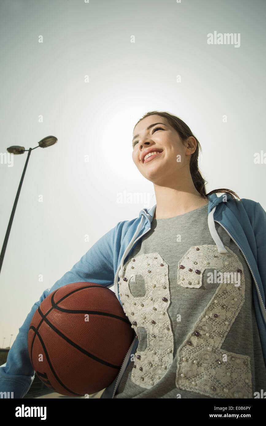Brunette young woman holding basket-ball extérieur Banque D'Images