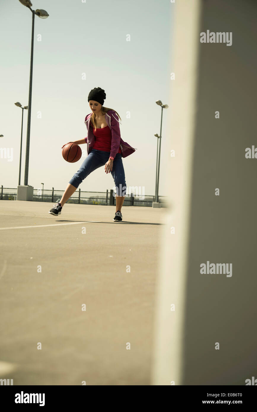 Jeune femme jouant au basket-ball extérieur Banque D'Images