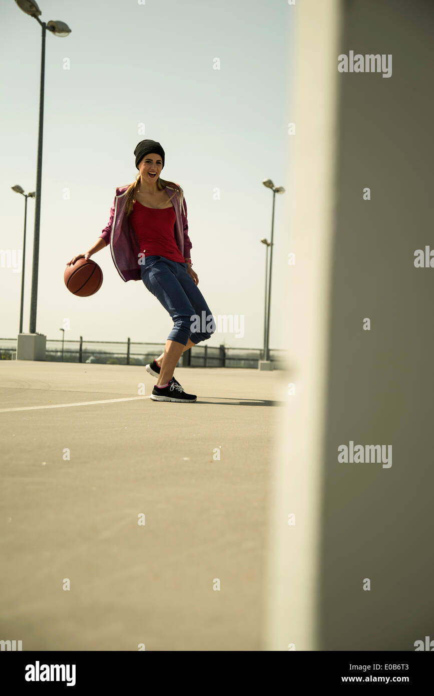 Jeune femme jouant au basket-ball extérieur Banque D'Images