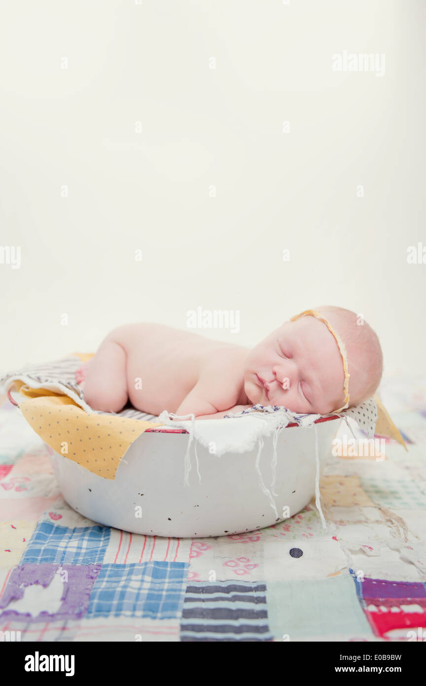 Bébé couché sur l'avant dans un bol Banque D'Images