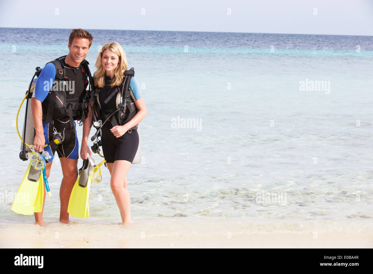 Couple avec équipement de plongée jouissant Plage Vacances Banque D'Images