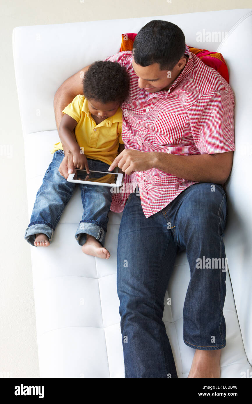 Vue de dessus de père et fils On Sofa Using Digital Tablet Banque D'Images Vue de dessus de père et fils On Sofa Using Digital Tablet Banque D'Images