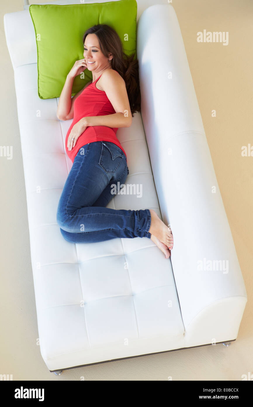 Vue de dessus de femme enceinte Relaxing On Sofa Banque D'Images Vue de dessus de femme enceinte Relaxing On Sofa Banque D'Images