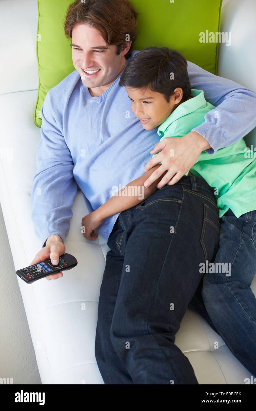 Vue de dessus de père et fils Relaxing On Sofa watching TV Banque D'Images Vue de dessus de père et fils Relaxing On Sofa watching TV Banque D'Images