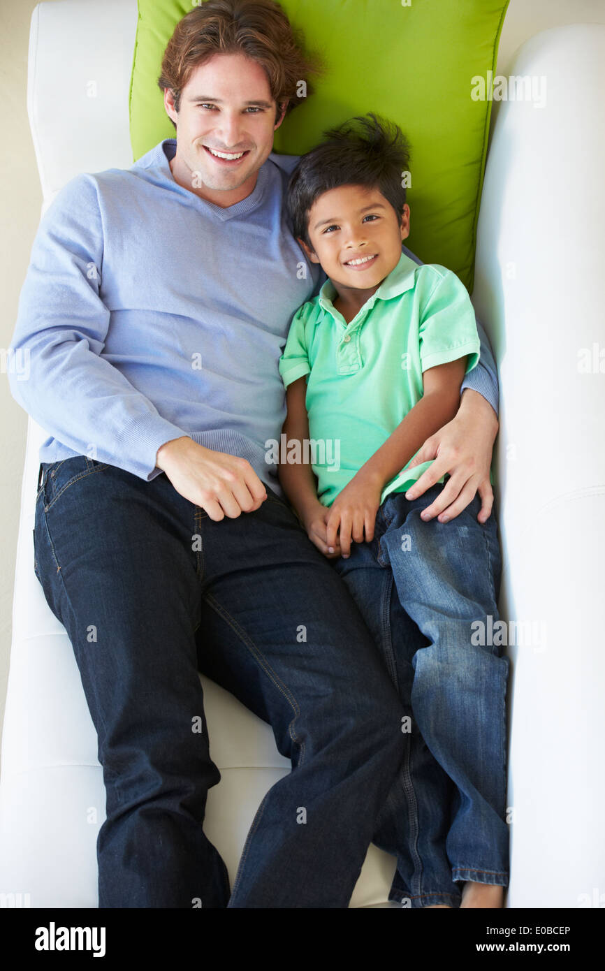 Vue de dessus de père et fils Relaxing On Sofa Banque D'Images Vue de dessus de père et fils Relaxing On Sofa Banque D'Images