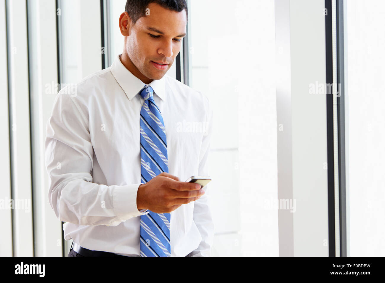 Businessman Using Mobile Phone In Office Banque D'Images