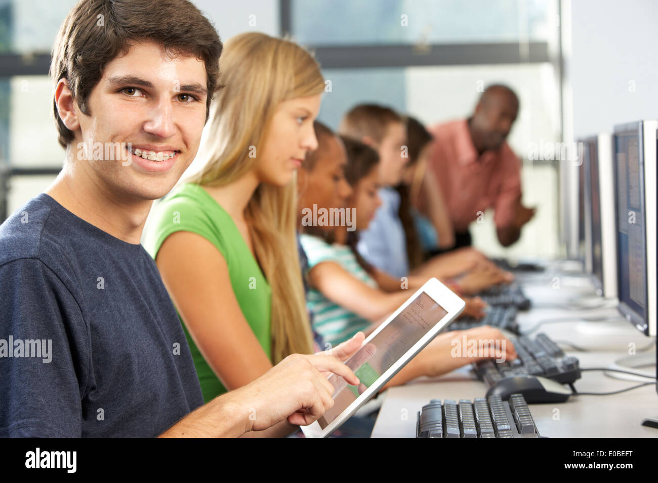 Boy Using Digital Tablet in Computer Class Banque D'Images